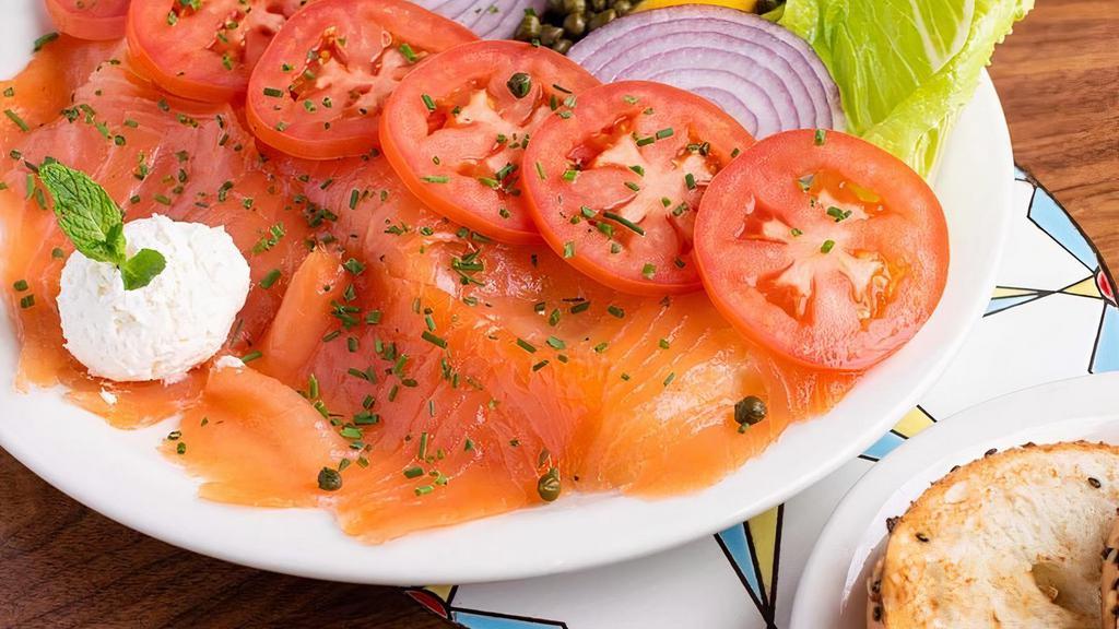 Smoked Salmon Plate · Our Fresh 100% natural salmon is locally smoked, it is served with a bagel, cream cheese, Roma tomatoes, Romaine lettuce, red onions, and capers.