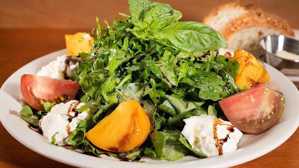 Heirloom Tomato & Burrata Salad (Seasonal) · Fresh Burrata cheese with heirloom tomatoes and baby arugula tossed in a Red Wine Vinaigrette and garnished with basil oil & a balsamic reduction.