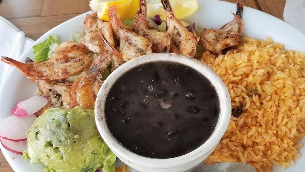 Camarones Rancheros · Tender shrimp sauteed with fresh onions, bell peppers and tomatoes, then simmered in our delicious spicy ranchero sauce. Served with fresh guacamole, rice and beans.