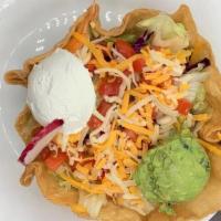 Tostada Salad · A crisp flour tortilla bowl filled with beans, lettuce, tomato and ground beef, topped with ...