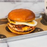 The Brekkie · House-made pork sausage patty, fried egg, bacon, cheddar cheese, sweet chili aioli, on a bri...