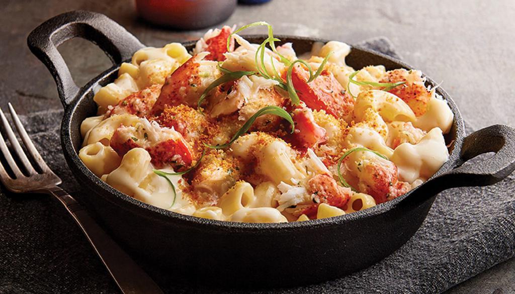 Lobster Mac N Cheese · Creamy white cheddar mac and cheese, lobster claw meat, panko bread crumbs. Parmesan cheese and green onions. Served with slice of garlic bread.