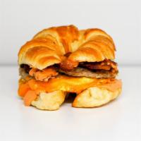 Croissant, Sausage, Bacon, Egg & Cheddar · 2 scrambled eggs, melted Cheddar cheese, smoked bacon, breakfast sausage, grilled onions, an...