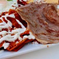 Golden Chilaquiles · Tortilla chips in a red, green, or mole sauce and topped with queso fresco, sour cream, and ...