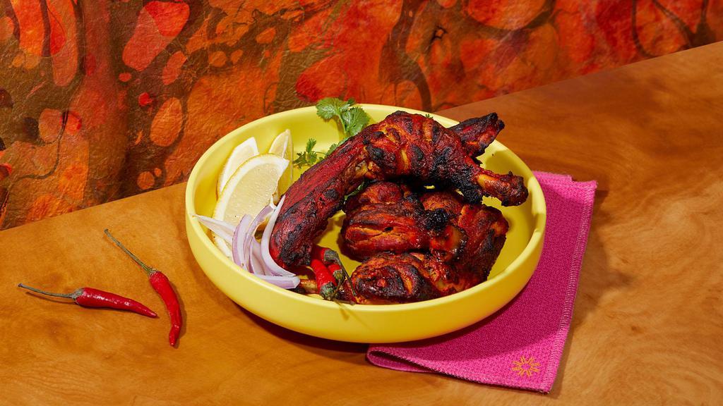 Tandoori Chicken · Spicy chicken with yogurt, ginger, garlic, and spices and char grilled in the tandoor grill.