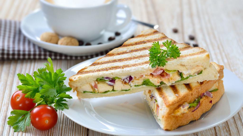 Roasted Turkey Breast Panini · Flavorful turkey breast, avocado, Swiss cheese, tomato, grilled onions, honey mustard, and mayo, served with a choice of side.