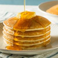 Original Buttermilk Pancakes · Three fluffy buttermilk pancakes topped with whipped cream. Maple syrup and butter on the si...