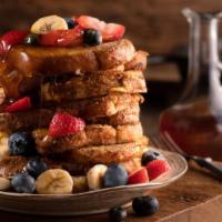 Strawberry Banana French Toast · Thick-cut french toast topped with fresh strawberries, banana slices, and dusted with powder...