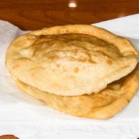 Bhatura · Two pieces of fried leavened bread.