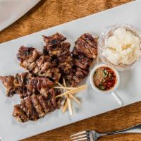 Moo Ping (Pork On Skewer) · Served with sticker rice. Grilled pork shoulder marinated with honey and Thai herbs on a ske...