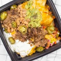 Short Rib Nachos · Homemade tortilla chips topped with braised short ribs, beans, cheddar cheese, jalapeños, so...