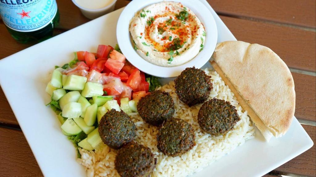 Falafel Plate · Vegetarian favorite. A mixture of garbanzo beans, vegetables, and spices cooked in canola oil in ball shapes. Served with hummus, tahini, pita bread, salad, and choice of rice, brown rice or fries.