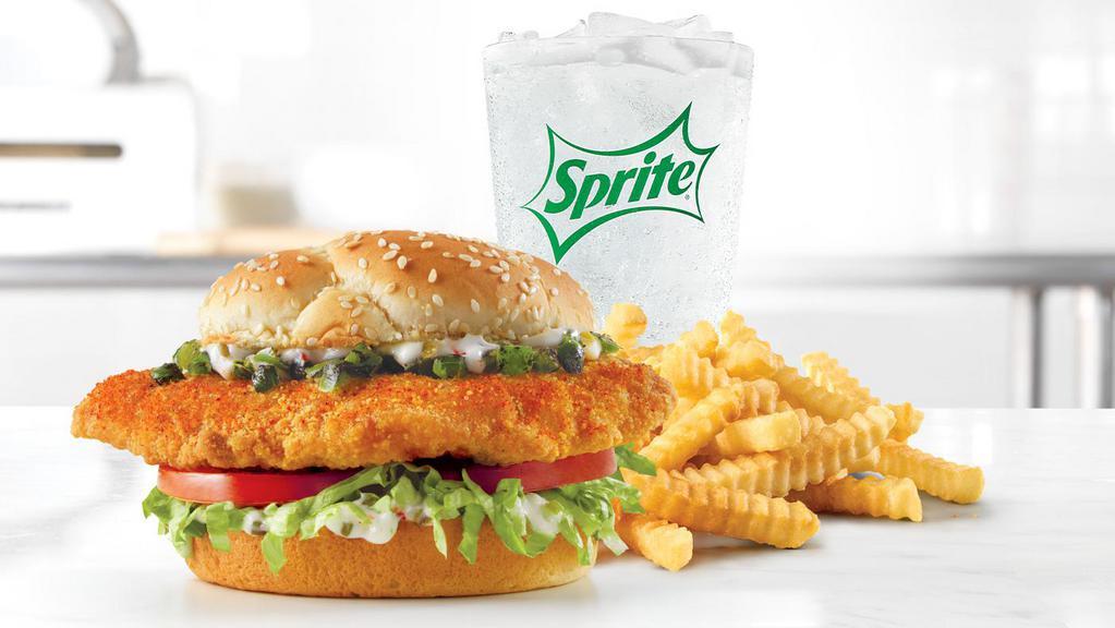 Spicy Fish Meal · A spicy seasoned crispy fish fillet topped with diced fire-roasted jalapeños, shredded lettuce, tomato, and tartar sauce on a toasted sesame bun.