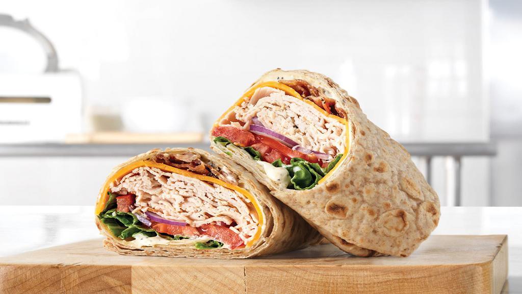 Roast Turkey Ranch & Bacon Wrap · Sliced roast turkey breast with pepper bacon, cheddar cheese, green leaf lettuce, tomato, red onion and parmesan peppercorn ranch sauce in an artisan wheat wrap. Visit arbys.com for nutritional and allergen information.