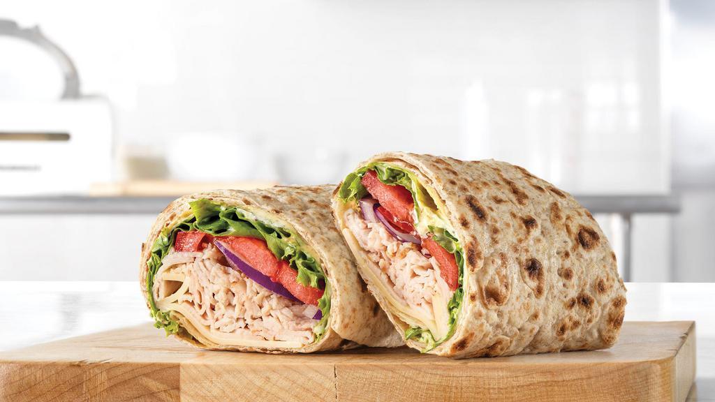 Roast Turkey & Swiss Wrap · Oven-roasted turkey, ripe tomatoes, lettuce, thinly sliced red onions, Swiss Cheese, mayo and spicy brown honey mustard. Together they make the Roast Turkey & Swiss wrap, the wrap roast turkey was made to go on.