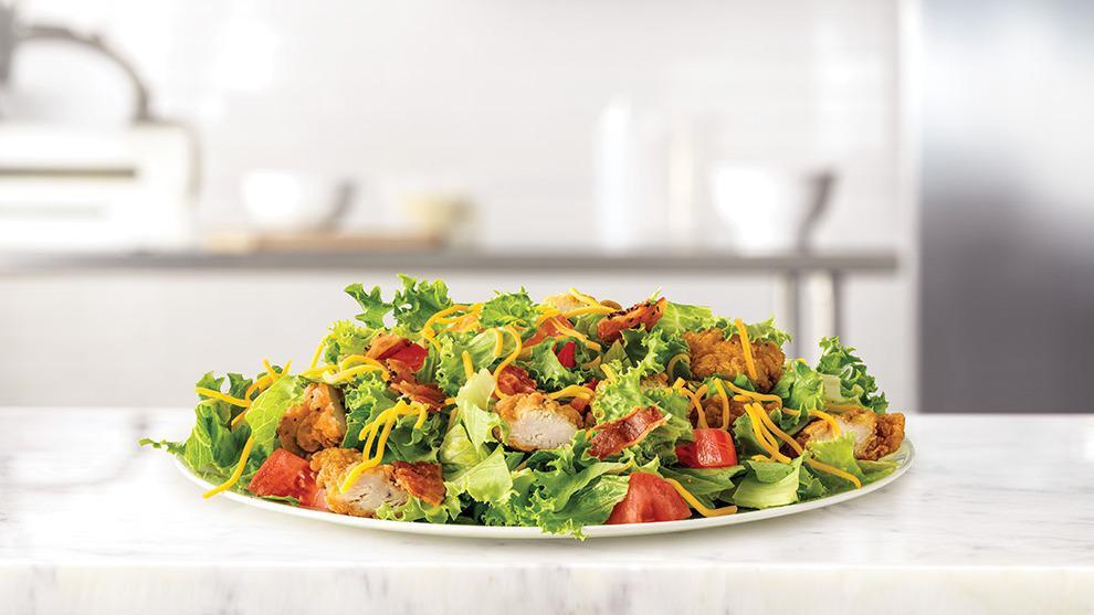Farmhouse Chicken Chopped Salad · Crispy chicken and diced pepper bacon on a bed of chopped fresh lettuce with diced tomatoes and shredded cheddar cheese. Visit arbys.com for nutritional and allergen information.