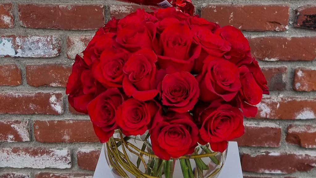 Rose Bowl With Valentine Mylar · Deep in the center of love there is an indescribable feeling of warmth, excitement, adventure and bursts of desire. 2 Dozen Red roses are the ultimate symbol of love.