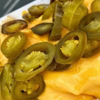 Nachos · nacho chips topped with nacho cheese and jalapeños