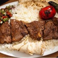 #19 Lamb Chop · Lamb Chops (Grass Fed) served with Rice, Pita Bread, Shirazi Salad, Grilled Tomatoes and Pep...