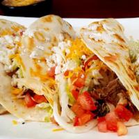 Judos' Tacos · An original creation crafted by the owner's son. Carnitas, cheese, black beans, lettuce, tom...