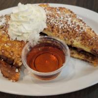 Nutella Banana French Toast · Four triangles of thick-cut French toast stuffed with Nutella spread and fresh banana dusted...