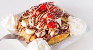 Katella Nutella Waffle · Belgian waffle topped with banana, strawberry, powdered sugar, vanilla ice cream, Nutella an...