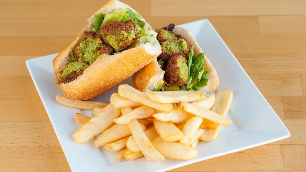 Falafel Sandwich · Vegetarian. Vegetarian patties with lettuce, tomato, pickle, and house dressing. Served in French baguette with a choice of green salad or French fries.