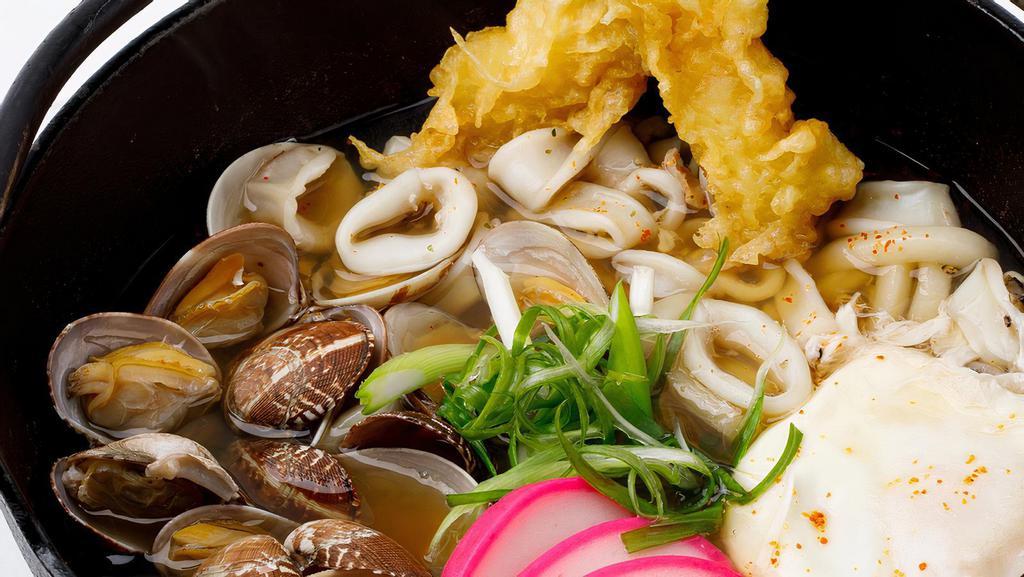 Seafood Nabeyaki Udon · Japanese udon noodle soup, clam, calamari, poached egg, shrimp tempura.
