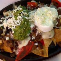 Nachos · Our homemade chips topped with black beans, melted cheese, jalapeños, guacamole, sour cream,...