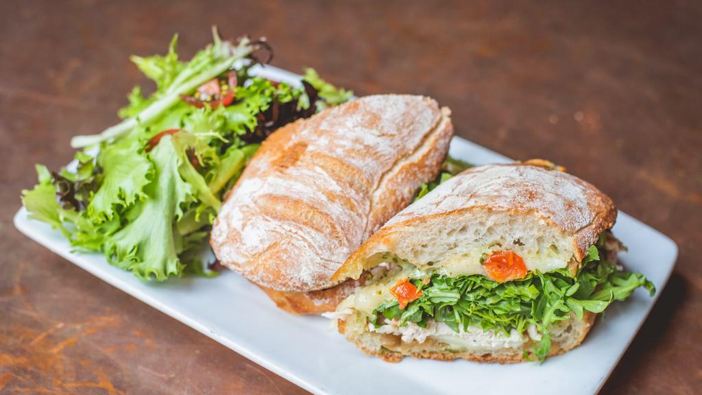 Grilled Chicken Sandwich · Provolone, oven roasted tomatoes, caramelized onion, arugula, basil aioli, artisan roll, served with greens