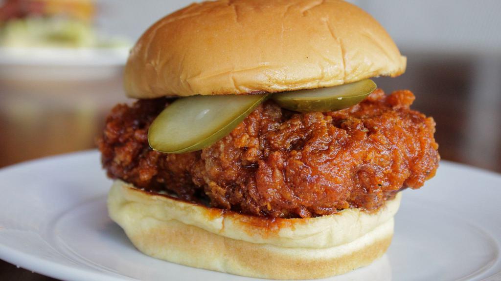 Nashville Hot Chicken · Nashville-style fried chicken, spicy pepper marinade, pickles.  Served on a potato bun with a side of slaw.