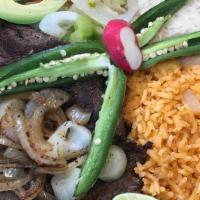 Carne Asada - Plate · Our traditional Top-Sirloin steak, seasoned and grilled with onions.<br />Served with corn o...