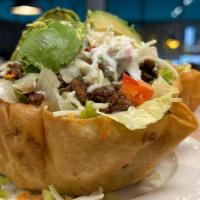 Steak Taco Salad · Carne Asada beef served in a crunchy flour tortilla shell with rice, beans, lettuce, tomatoe...