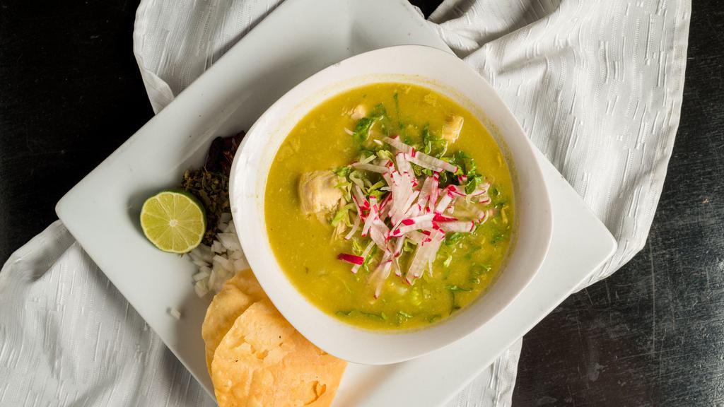 Pozole Verde Con Pollo · Gluten-free. Traditional pre-colonial soup made with a lite tomatillo base, hominy in a cilantro broth
with shredded chicken breast. Garnished with diced white onions, oregano,
lime wedges and served with tostadas.