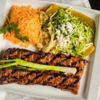 Arrachera Méxicana Con Enchilada · Marinated flank steak paired with a green chicken enchilada and rajas de chile poblano. Serv...