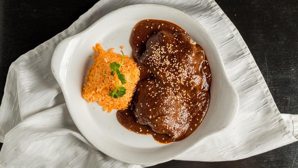 Mole Poblano Con Pollo · Signature dishes from Puebla. Mole made with 32 ingredients. Served with braised chicken and tortillas on the side.