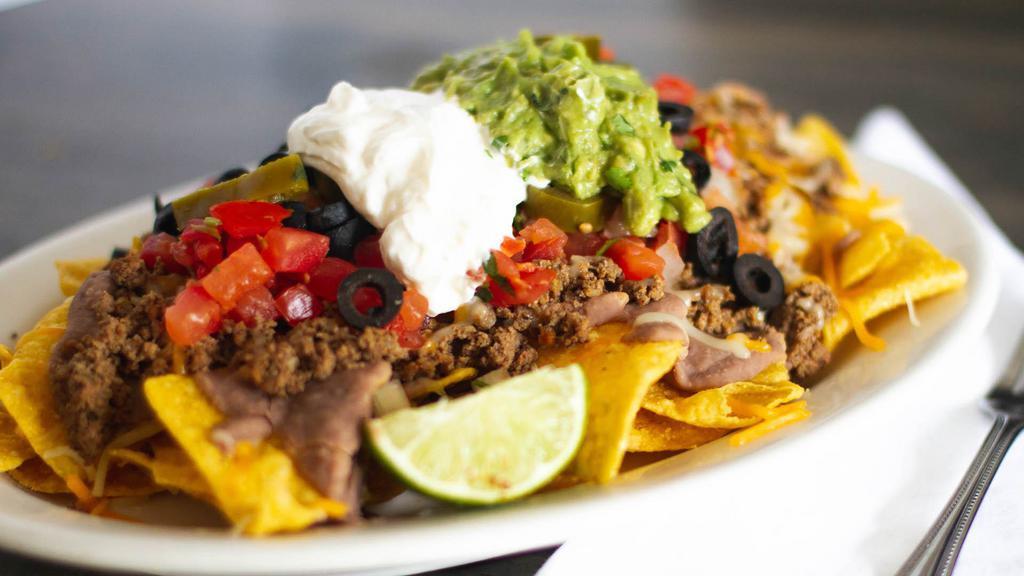 Super Nachos · Your choice of meat, chips, beans, cheese, tomatoes, jalapeños, sour cream, guacamole and olives.