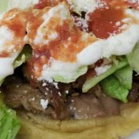 Sope · Choice of meat, beans, lettuce, tomato sauce, sour cream, and cheese.