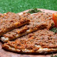 Lahma Ajoun · homemade fresh dough spread with marinated ground meat mixed with tomatoes, parsley and onions