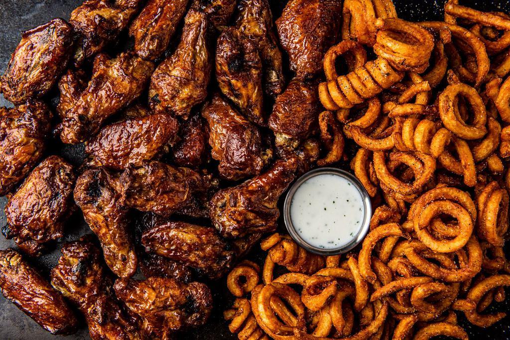 32 Smoked Bone-In Wings · 32 bone-in wings smoked in-house over pecan wood then tossed with your choice of 4 flavors. Served with curly fries and a side of ranch.