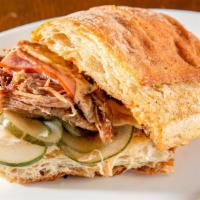 Cuban Style Sandwich · With braised pork, ham, swiss cheese, dill pickles served on a toasted roll