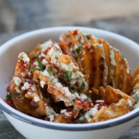 Criss Cross Fries · Waffle fries topped with house made jalapeno ranch, house made hot sauce, feta cheese and or...