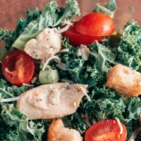 Chicken Pesto Salad · Rich kale topped with chicken, parmesan, croutons, and tomatoes brought into perfect harmony...