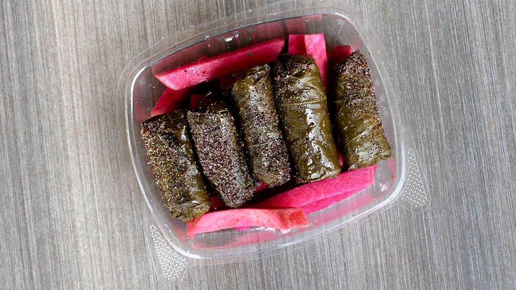 Grape Leaves (Dolmas) (5 Pcs) · Pickled Grape Leaves Stuffed With Rice and Vegetables Cooked and Served Cold Over a Bed of Pickled Turnips Toped with Spices.