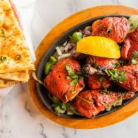 Tandoori Chicken (6) · Six pieces of chicken marinated in lemon juice, onion, herbs and spices baked in clay oven.