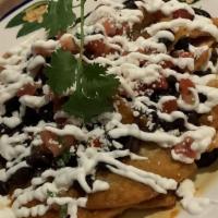 Nachos · Tortilla chips, ranchero sauce, black beans, pico, sour cream, cotija.