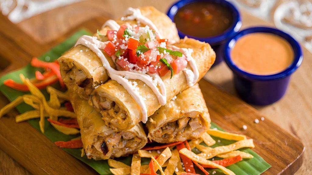 Crispy Flautas · Four crispy flour tortillas filled with grilled chicken and jack cheese. Topped with cotija cheese, crema fresca, pico de gallo and served with jalapeño jelly and red pepper dip.