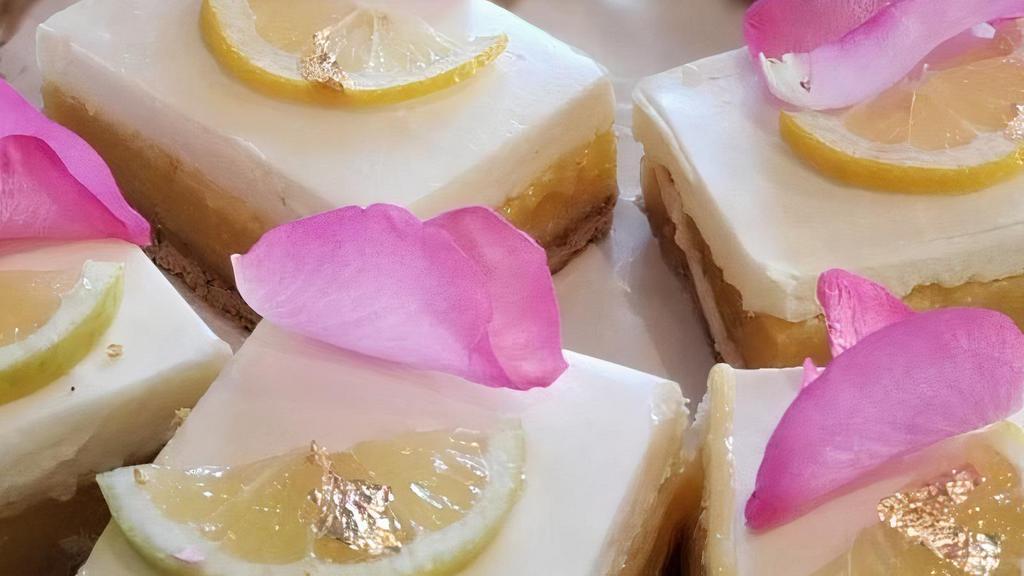Lemon Bar Cheesecake · A creamy layer of cheesecake on top of our popular Lemon Bar.

ALLERGEN INFORMATION:
Contains: wheat, milk, eggs, & pecans.