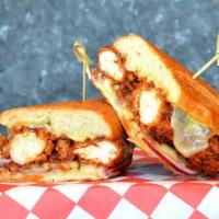 Nashville Po'Boy · Crispy Nashville hot chicken tenders pressed in a French roll with Monterey jack cheese, dil...