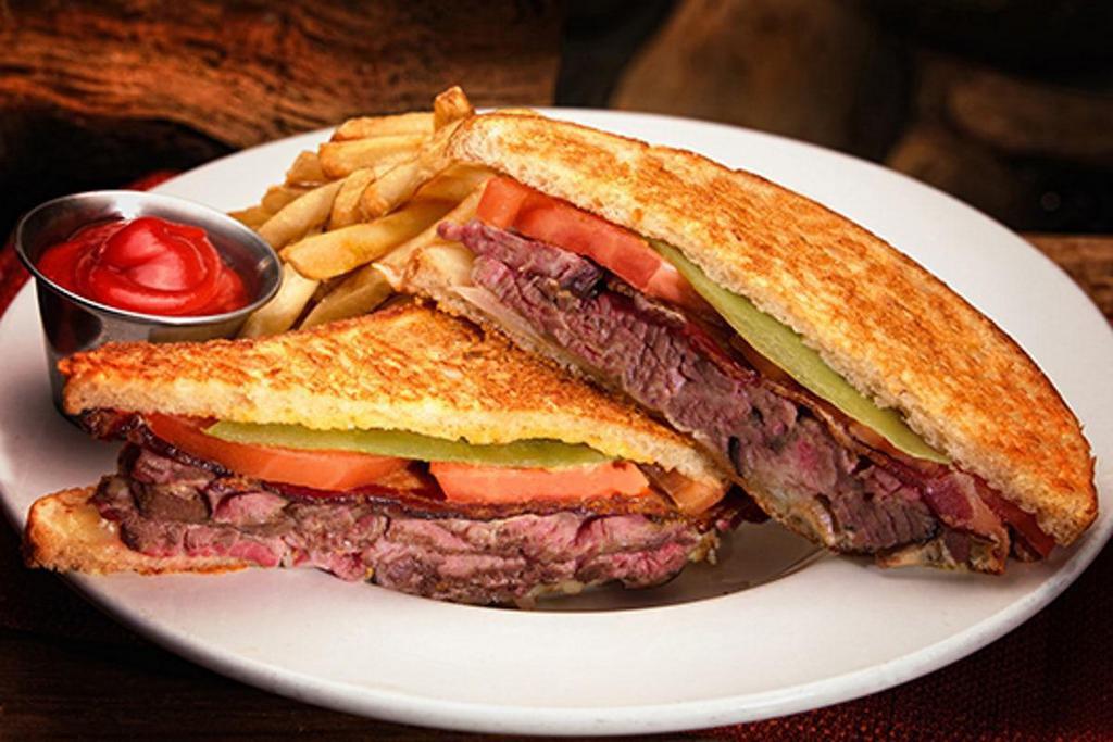 Joe'S Steak Sandwich · Hand-carved Joe's Steak®, mushrooms, onions, tomatoes, bacon, cheese, a green chile and Thousand Island dressing between grilled Parmesan bread. Served with hand-cut Cabin Fries.